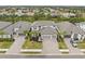 An aerial view shows the home and surrounding neighborhood with paved driveways and tropical landscaping at 1012 Fernleaf Run, Bradenton, FL 34212
