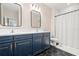 Modern bathroom with a double sink vanity, hexagon tile flooring, and a shower with white subway tile at 1012 Fernleaf Run, Bradenton, FL 34212