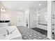 Elegant bathroom with soaking tub, dual vanities, and glass-enclosed shower featuring stylish black-and-white patterned floors at 1012 Fernleaf Run, Bradenton, FL 34212