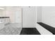 Modern bathroom showcasing a glass shower with bench and dual vanities, and stylish black-and-white patterned tile floors at 1012 Fernleaf Run, Bradenton, FL 34212