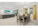 Open concept dining area features a wooden table and is filled with natural light from the windows at 1012 Fernleaf Run, Bradenton, FL 34212