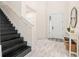 Inviting entryway with dark wood stairs, light wood-look floors, and a stylish console table at 1012 Fernleaf Run, Bradenton, FL 34212