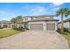 Stylish two-story home with a brick driveway, a three-car garage, and lush landscaping in a serene setting at 1012 Fernleaf Run, Bradenton, FL 34212