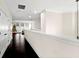 Bright upstairs hallway with hardwood floors leads to windows and a partial view of a Christmas tree at 1012 Fernleaf Run, Bradenton, FL 34212