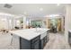A kitchen with a large island, white cabinetry, stainless steel appliances and an open concept floorplan at 1012 Fernleaf Run, Bradenton, FL 34212