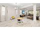 Bright and airy living room featuring light wood floors, large windows, and an open floorplan to the dining area at 1012 Fernleaf Run, Bradenton, FL 34212