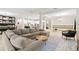 Spacious living room with large sectional sofa, and an open floorplan to the kitchen and dining area at 1012 Fernleaf Run, Bradenton, FL 34212