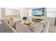 A living room with a modern sofa, large TV, and open concept layout, perfect for entertaining at 1012 Fernleaf Run, Bradenton, FL 34212
