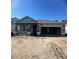 An incomplete single-story house with a two-car garage and a covered porch in an unfinished lot at 19591 Fort King Run, Brooksville, FL 34601