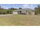 Well-kept single-Gathering home with green lawn, mature trees, and a two-car garage at 230 Salisbury St, Port Charlotte, FL 33954