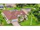 Beautiful aerial view of a single Gathering home with a brown roof, lush landscaping and in-ground pool at 26071 Paysandu Dr, Punta Gorda, FL 33983