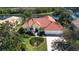 Aerial view of a home with well-manicured landscaping, a tile roof, and a waterfront backyard at 3716 Eagle Hammock Dr, Sarasota, FL 34240
