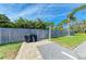 Outdoor space with a gray fence surrounding the property, landscaping and a barbecue grill with paving stones at 401 Shore Rd, Nokomis, FL 34275