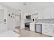 Updated kitchen boasts stainless steel appliances, white cabinetry, stylish backsplash, and an adjacent dining area at 4350 Chatham Dr # 208, Longboat Key, FL 34228