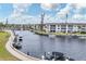 Scenic waterfront view of the complex featuring a canal with boats and lush landscaping under a partly cloudy sky at 4350 Chatham Dr # 208, Longboat Key, FL 34228