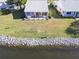 Aerial view of a waterfront property with a spacious yard, a patio, and rocky shoreline at 4714 Potomac Cir, Bradenton, FL 34210