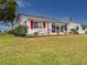 Charming patio with seating offers a relaxing outdoor space with vibrant red shutters at 4714 Potomac Cir, Bradenton, FL 34210