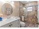 Cozy bathroom featuring a tiled shower with glass doors and a round mirror above a white vanity at 4714 Potomac Cir, Bradenton, FL 34210