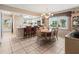 Bright dining room with tile floors, chandelier, and adjacent kitchen bar seating area at 4714 Potomac Cir, Bradenton, FL 34210