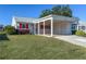 Charming home with a well-maintained lawn, carport, red shutters, and beautiful landscaping at 4714 Potomac Cir, Bradenton, FL 34210