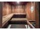 Wood-paneled sauna room with tiered benches and a 'Dry Sauna No Water' sign for relaxation at 4714 Potomac Cir, Bradenton, FL 34210