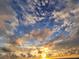 Dramatic sky at sunset with clouds illuminated in shades of orange and yellow against a blue backdrop at 4714 Potomac Cir, Bradenton, FL 34210