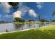 Picturesque water view with lush green grass, docks, and a clear blue sky backdrop at 4714 Potomac Cir, Bradenton, FL 34210