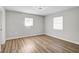 Bright bedroom with neutral walls, laminate flooring, and natural light from two windows at 5445 Bahia Vista St, Sarasota, FL 34232