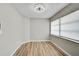 Bright bedroom with neutral walls, wood-look flooring, and window with blinds offer a serene retreat at 5445 Bahia Vista St, Sarasota, FL 34232