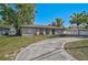 Charming single-story home with a circular driveway and well-manicured lawn, great curb appeal at 5445 Bahia Vista St, Sarasota, FL 34232