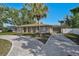 Charming single-story home with a circular driveway and well-manicured lawn, great curb appeal at 5445 Bahia Vista St, Sarasota, FL 34232