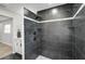 Sleek walk-in shower featuring dark tile, mosaic accents, and modern fixtures offer a spa-like experience at 5445 Bahia Vista St, Sarasota, FL 34232