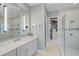 Spa-like bathroom with glass shower, sleek fixtures, and a view into the walk-in closet at 8261 Grande Shores Dr, Sarasota, FL 34240