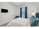 Bright bedroom with a TV, blue accents, double door closet, and window with shade at 8261 Grande Shores Dr, Sarasota, FL 34240