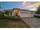 Charming single-story home featuring a three-car garage, well-manicured lawn, and decorative landscaping at 8261 Grande Shores Dr, Sarasota, FL 34240