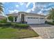 Well-maintained single-Gathering home with a three-car garage, lush lawn, and paved driveway at 8261 Grande Shores Dr, Sarasota, FL 34240