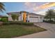 Charming single-story home with a manicured lawn, three car garage and beautiful desert landscaping at 8261 Grande Shores Dr, Sarasota, FL 34240