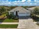 Beautiful home featuring a well-manicured lawn, lush landscaping, and a spacious three-car garage at 8261 Grande Shores Dr, Sarasota, FL 34240