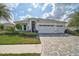 Attractive home with a three-car garage, manicured lawn, and stone-paved driveway at 8261 Grande Shores Dr, Sarasota, FL 34240