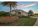 Attractive single-Gathering home showcasing vibrant flowers, palm trees, and a well-maintained lawn at 8261 Grande Shores Dr, Sarasota, FL 34240