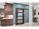 Stylish interior features custom sliding glass door, brown cabinets and appealing light blue accent wall at 8261 Grande Shores Dr, Sarasota, FL 34240