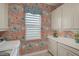 A vibrant laundry room with custom cabinets, quartz counters, patterned wallpaper, and natural light at 8261 Grande Shores Dr, Sarasota, FL 34240