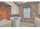 Bright laundry room featuring a washer, dryer, sink, and colorful wallpaper at 8261 Grande Shores Dr, Sarasota, FL 34240