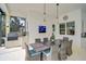 Outdoor dining area featuring a grill, sink, dining table with seating for eight, and modern light fixtures at 8261 Grande Shores Dr, Sarasota, FL 34240