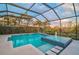 Enjoy a private screened pool with a spa and water feature, surrounded by lush landscaping and a view at 8261 Grande Shores Dr, Sarasota, FL 34240