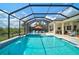 Enjoy this screened outdoor pool and fountain spa, featuring a dining area and outdoor kitchen at 8261 Grande Shores Dr, Sarasota, FL 34240