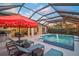 The screened lanai features a pool with fountain, hot tub, sun loungers, and an outdoor kitchen with a covered dining area at 8261 Grande Shores Dr, Sarasota, FL 34240
