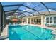 Large screened-in pool with a spa, water feature, and surrounding patio, providing a perfect space for outdoor relaxation and fun at 8261 Grande Shores Dr, Sarasota, FL 34240