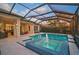Enjoy a private screened pool with a spa and water feature, set amidst lush landscaping and scenic views at 8261 Grande Shores Dr, Sarasota, FL 34240