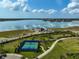 Aerial view of the tennis court with the lake view in the background at 8261 Grande Shores Dr, Sarasota, FL 34240